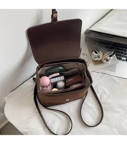 Spacious interior of vintage brown backpack showing phone, umbrella and daily essentials