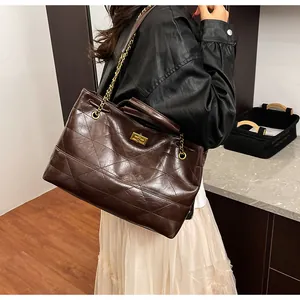 Detail of vintage brown quilted tote bag with gold twist lock and chain strap