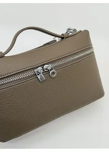 Close-up of premium brown lychee grain leather handbag with dual metal zippers