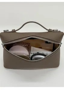 Detailed interior of a brown leather lunchbox bag showing space for cosmetics and phone