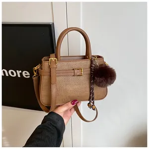 Detail of vintage brown bucket bag featuring woven texture and plush charm accessory
