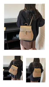 Detail view of a retro brown faux suede backpack with flap buckle and top handle