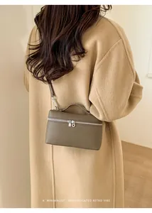 Detail of minimalist khaki leather lunch box bag showing silver zippers and refined texture
