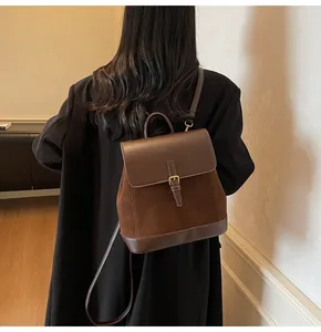 Detail showing the brown suede texture and vintage buckle strap on this stylish backpack