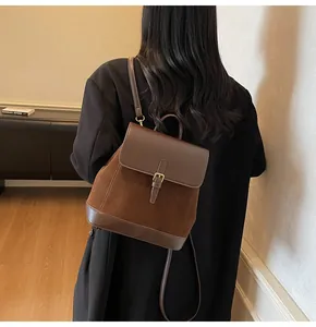 Detail of brown vintage suede backpack with gold buckle and adjustable strap on a model