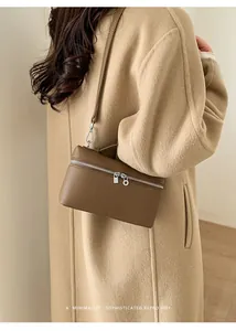 Brown lychee leather crossbody bag styled with a camel coat for a retro daily outfit