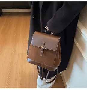 Detail of vintage brown suede backpack with buckle closure and matte leather texture