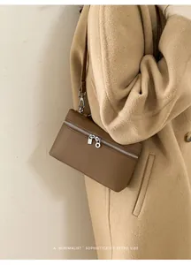 Close-up of minimalist brown litchi pattern leather vanity bag with metal zipper detail