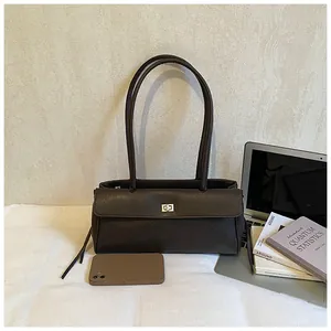 Detail of dark brown rectangular shoulder bag featuring matte faux leather and gold twist lock