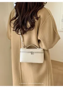 Detail of cream leather handbag styled with a camel coat for a sophisticated retro vibe