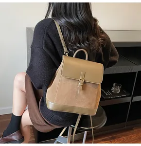 Brown faux leather and vintage suede backpack with metal buckle on the back of a model