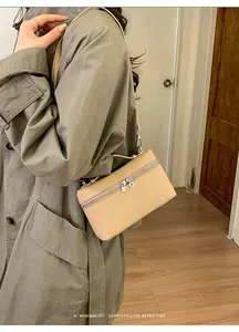 Detail of light beige box bag featuring wrap-around double zippers and matte leather