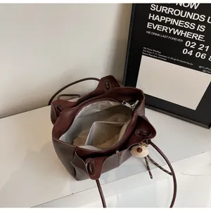Top view of large brown tote bag interior with multiple compartments and plush bear charm
