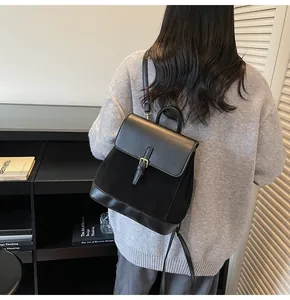 Detail view of the contrast texture black backpack featuring leather flap and suede body