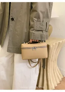 Minimalist beige box bag with leather texture shown in a sophisticated lifestyle setting