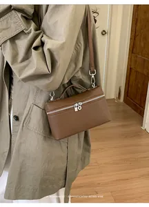 Brown lychee leather box bag worn as a crossbody style for a minimalist retro look