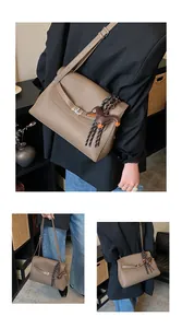 Detail of brown pebbled leather shoulder bag with silver clasp and leather puppy charm