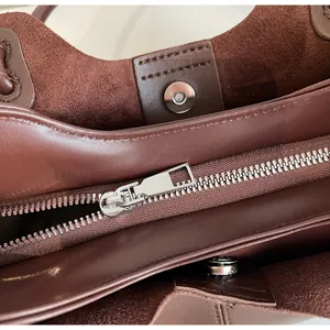 Detail of premium silver metal zipper and magnetic closure on large brown tote bag