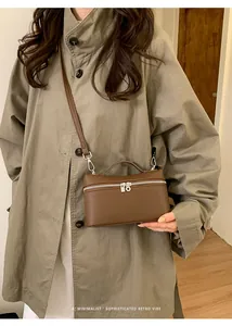 Brown lychee leather mini box bag styled with a khaki trench coat for a retro look