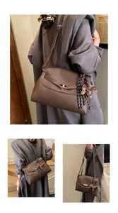 Close-up of brown pebbled leather briefcase with silver turn-lock and dog charm detail