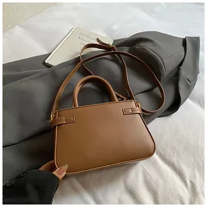 Detailed shot of brown PU leather bucket bag with gold hardware on minimalist background