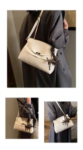 Detail of off-white lychee leather briefcase with metal twist lock and dog charm