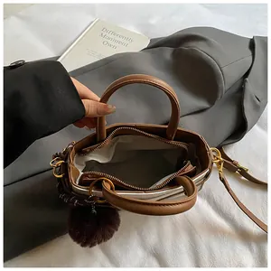 Top view of two-tone bucket bag showing zipper closure, interior lining and plush charm