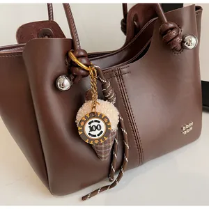 Close-up of the knot handle with a silver metal ball on a dark brown tote bag
