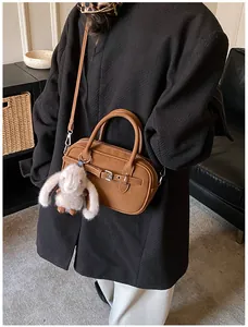 Detail of vintage brown faux leather crossbody bag with cute plush rabbit charm