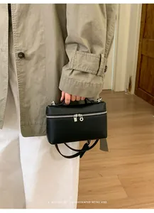 Detail of black lychee grain leather handbag with silver two-way zipper and top handle