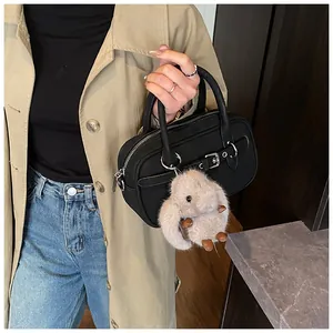 Detail of a vintage black square bag with a silver zipper and a plush rabbit charm