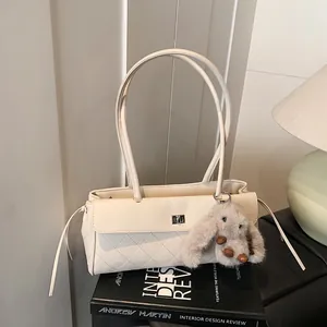 Creamy white quilted shoulder bag with metal lock and plush rabbit charm detail