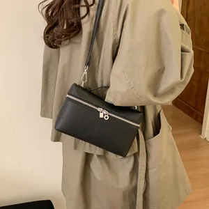 Black lychee texture box bag with silver zippers shown in a crossbody style