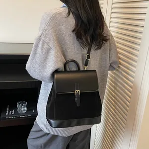 Minimalist black faux suede patchwork backpack with gold buckle and top handle