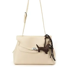Cream pebbled leather satchel with silver twist lock and decorative dog charm