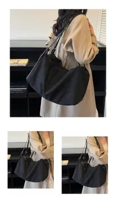 Detail of matte black hobo tote bag featuring adjustable leather shoulder strap