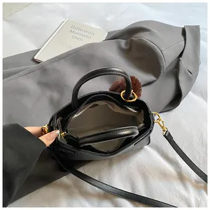 Interior view of black bucket bag showing zipper compartment and soft lining details