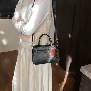 Retro black bucket bag for women with gold buckle and fuzzy charm for daily style