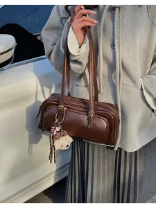 Detail of vintage brown bowling bag with adjustable straps and plush bear charm decoration