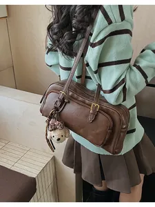 Detail of vintage brown bowling bag with double zipper and cute plush puppy keychain