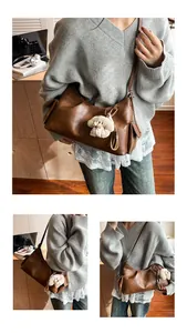 Close-up of brown retro pillow bag in PU leather featuring a cute white plush puppy charm