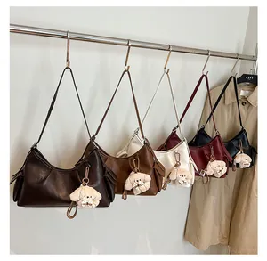 Detail of trendy retro shoulder bags in five colors with cute plush puppy charms