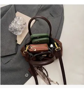 Vista interior del bolso tipo cubo de ante marrón que muestra su capacidad para el móvil