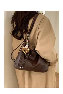 Deep brown retro tote bag shown on model with plush bear charm and star pendant detail
