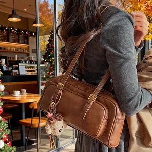 Retro brown leather bowling bag with cute puppy pendant in a warm cafe setting