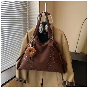 Detail der dunkelbraunen Wildleder-Tote mit Nieten und weichem Donut-Anhänger