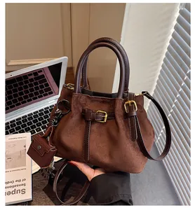 Detailaufnahme der Wildleder-Eimertasche mit Kordelzug und kleiner Münztasche