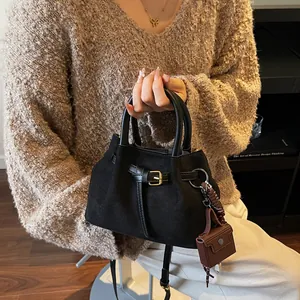 Schwarze Bucket-Bag aus Wildlederimitat mit goldener Schnalle und Mini-Charm für den Alltag