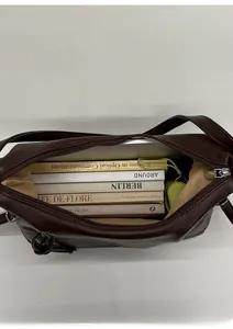 Top view of spacious interior of brown PU leather tote bag with books and lining
