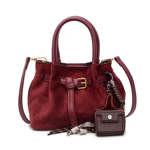 Bolso cubo de ante burdeos con correa de cuero y amuleto decorativo en estilo vintage